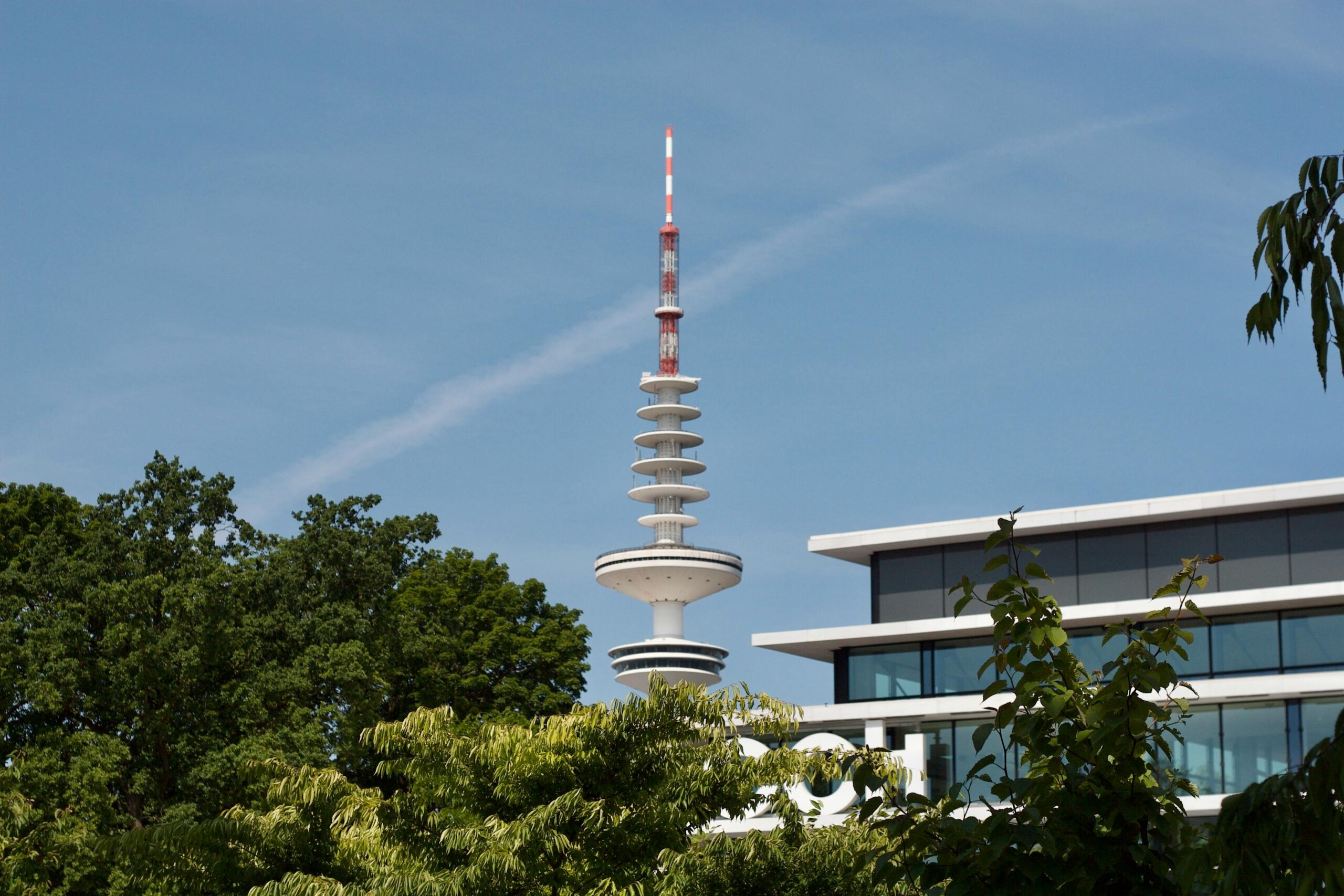 Blick auf den berühmten Heinrich-Hertz-Turm zwischen Bäumen in Hamburg, Deutschland, an einem sonnigen Tag.